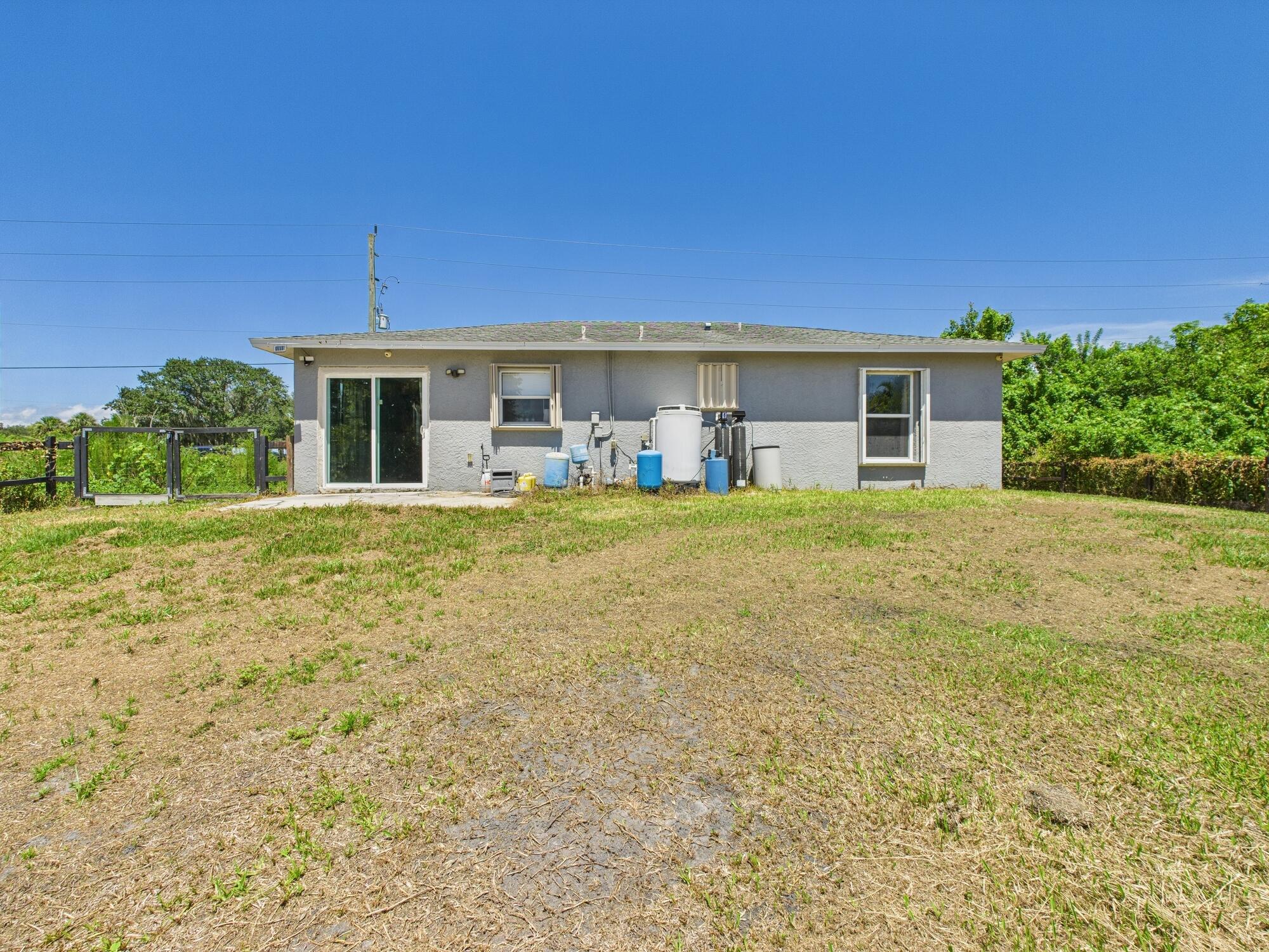 6504 Southeast 86th Boulevard Okeechobee, FL 34974 - Photo 34 of 38 a view of a house with a big yard and potted plants