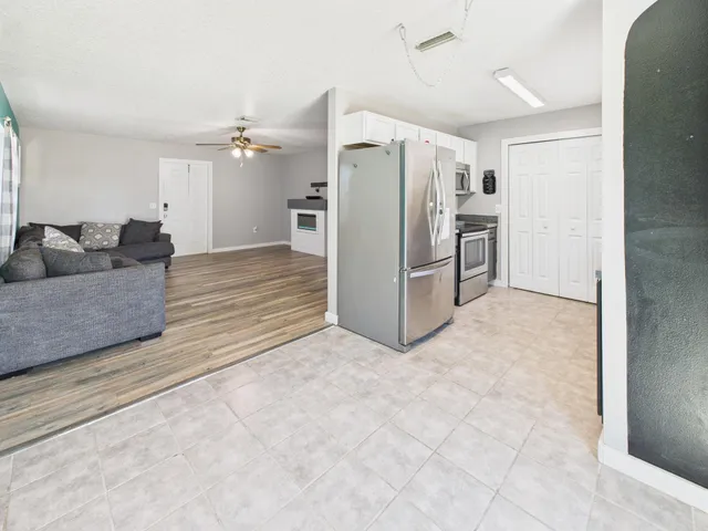 a living room with furniture and a refrigerator