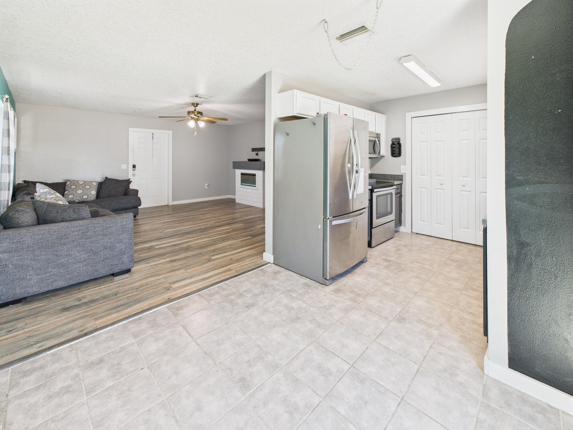 6504 Southeast 86th Boulevard Okeechobee, FL 34974 - Photo 6 of 38 a living room with furniture and a refrigerator