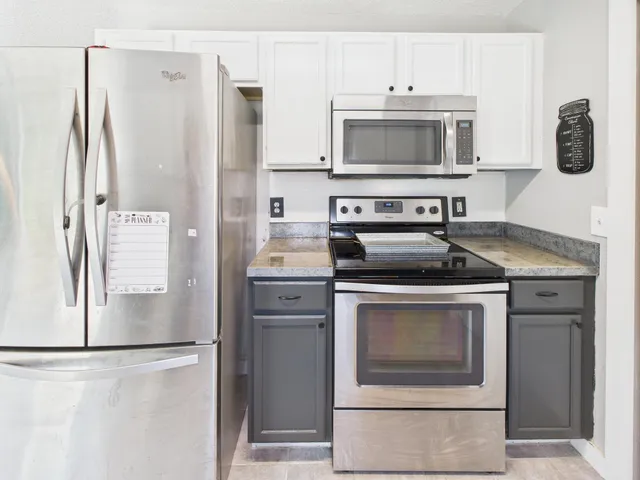 a kitchen with stainless steel appliances a refrigerator stove and microwave