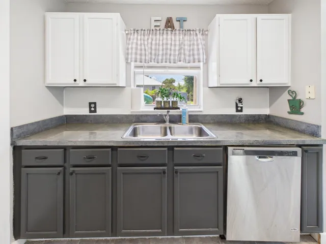 a kitchen with granite countertop white cabinets white appliances and a sink