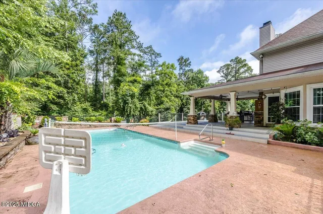 a view of a house with swimming pool and sitting area