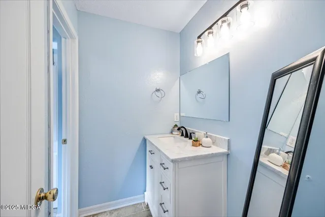 a bathroom with a sink vanity and a mirror