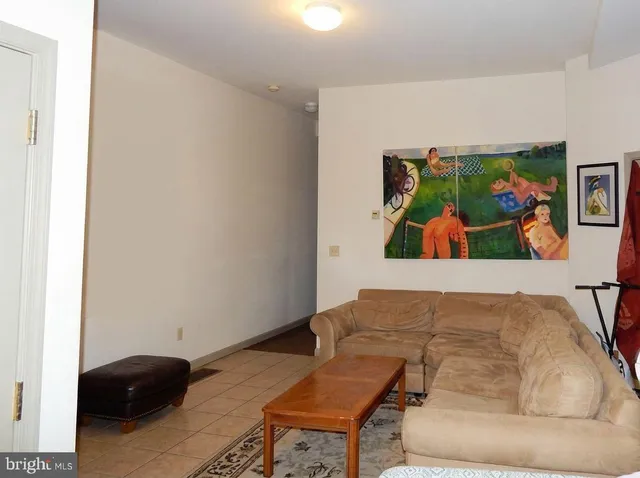 a living room with furniture and painting on the wall