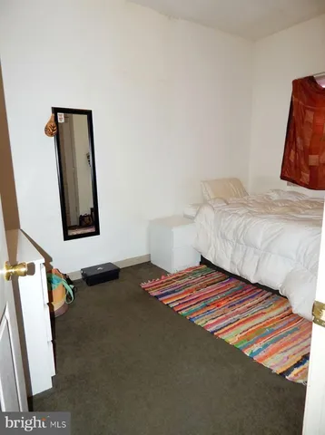 a bedroom with a bed and painting on the wall