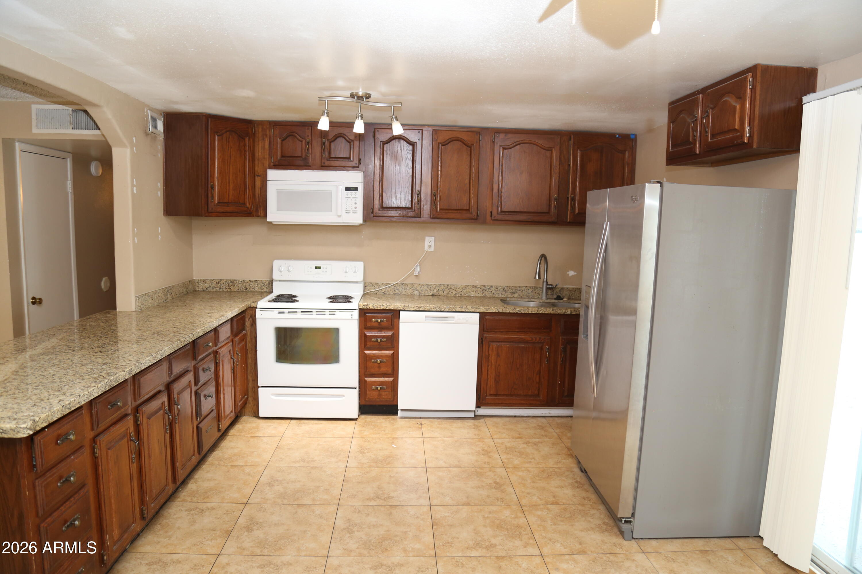 13238 North 38th Place Phoenix, AZ 85032 - Photo 10 of 19 a kitchen with stainless steel appliances granite countertop a refrigerator a stove and a sink