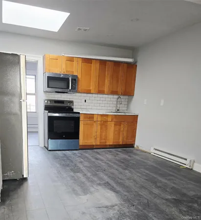 a kitchen with stainless steel appliances a stove top oven a sink and a microwave