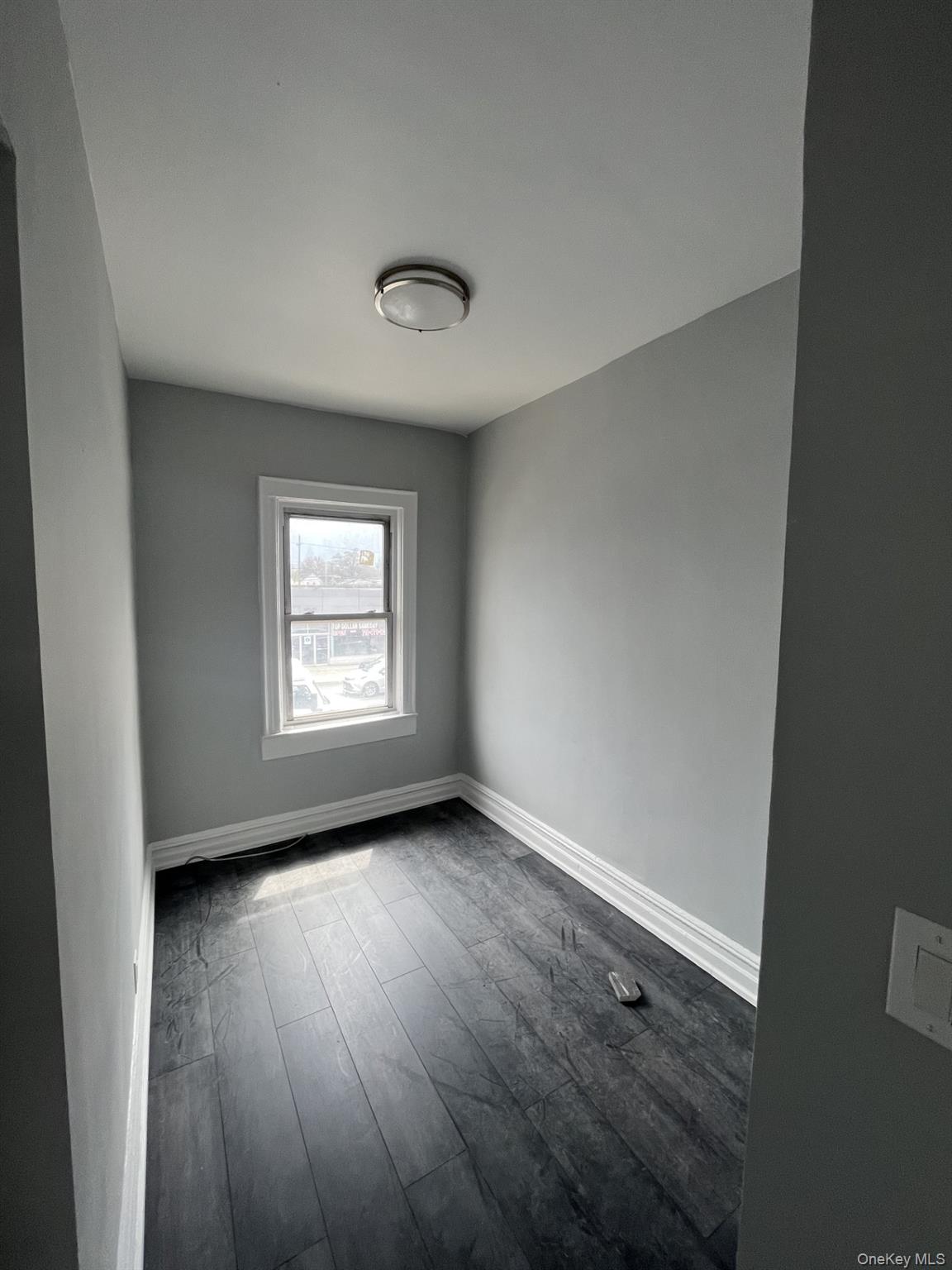 211-45 Jamaica Avenue Queens, NY 11428 - Photo 3 of 4 an empty room with wooden floor and windows