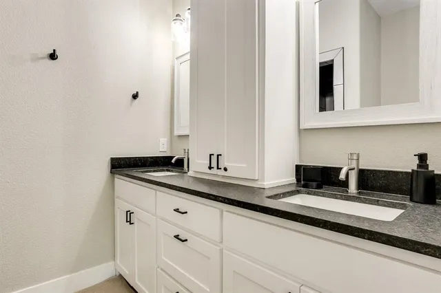 a kitchen with granite countertop white cabinets and sink