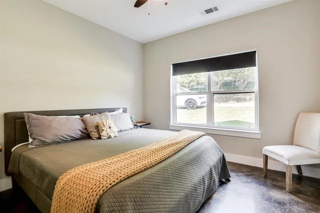 a large bed sitting in a bedroom next to a window