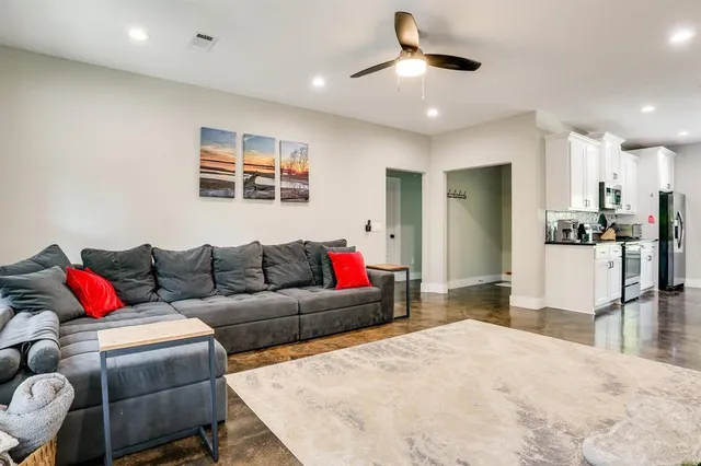 a living room with furniture and kitchen view