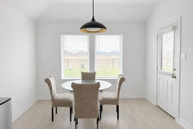 a dining room with furniture a chandelier and a rug
