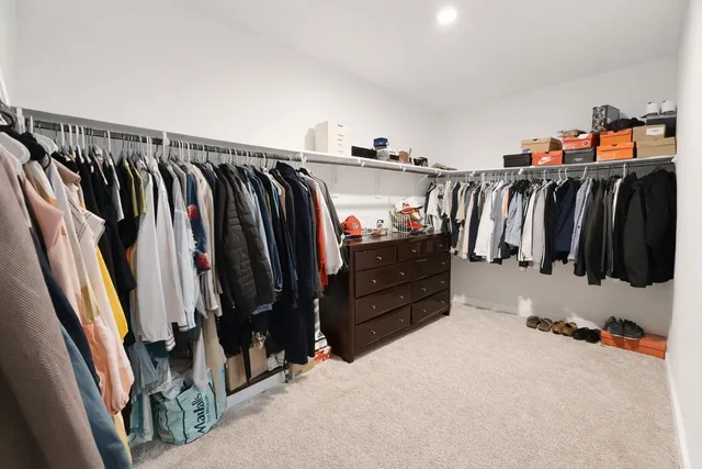 a view of walk in closet with clothes and shoes