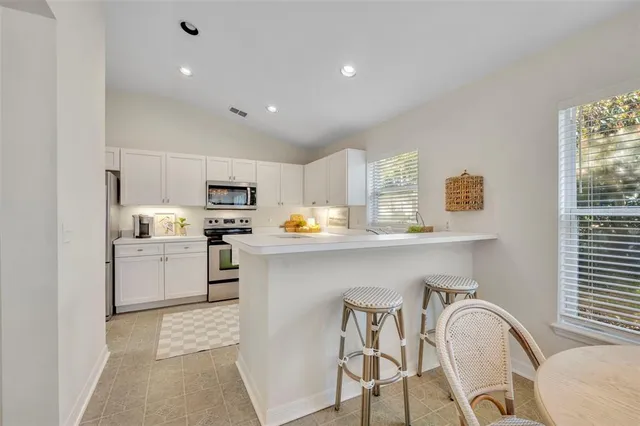 a kitchen with granite countertop white cabinets and white appliances