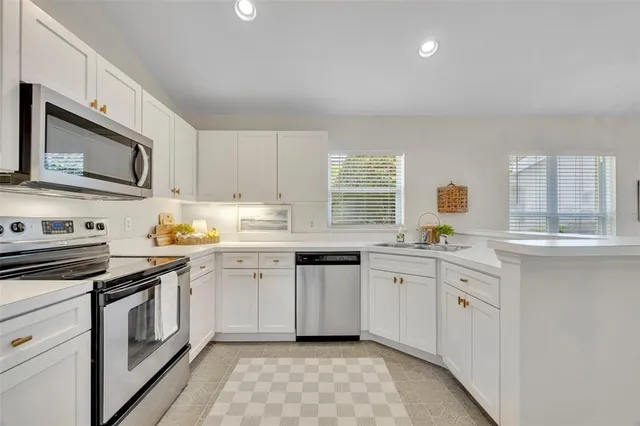 a kitchen with cabinets stainless steel appliances and a counter space