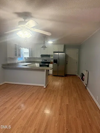 a kitchen with a wooden floor and stainless steel appliances