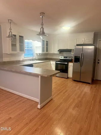 a kitchen with granite countertop a refrigerator and a sink