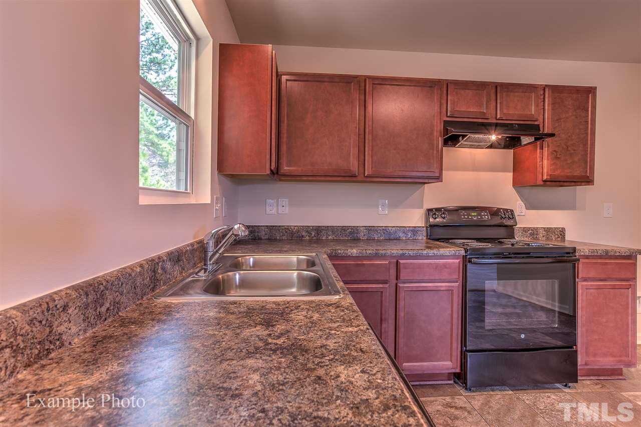 9673 Jernigan Road Spring Hope, NC 27882 - Photo 9 of 24 a kitchen with granite countertop a stove and cabinets
