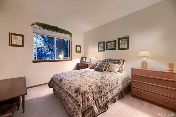 a bedroom with bed and a desk