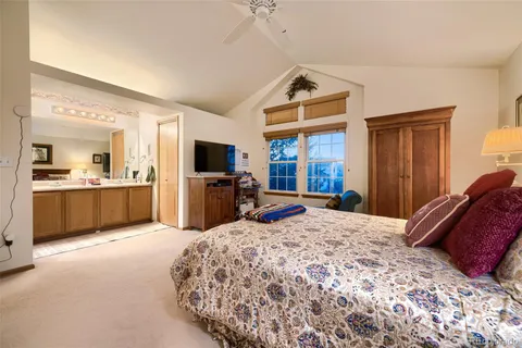 a large bedroom with a bed and a view of kitchen