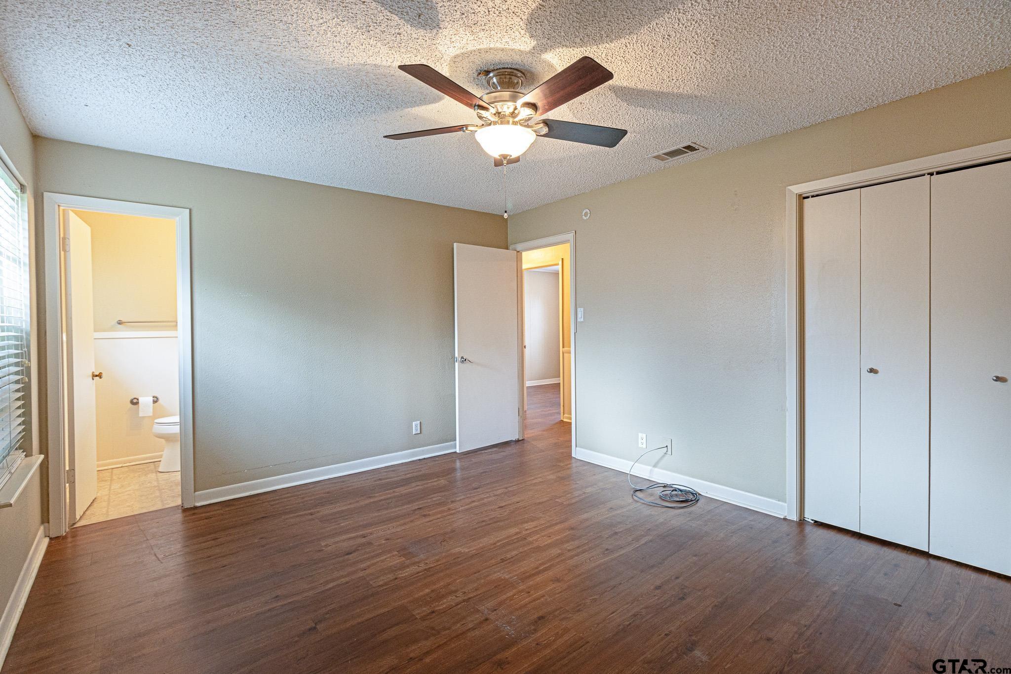 1202 Ridgeview Drive Tyler, TX 75701 - Photo 13 of 20 an empty room with wooden floor and ceiling fan
