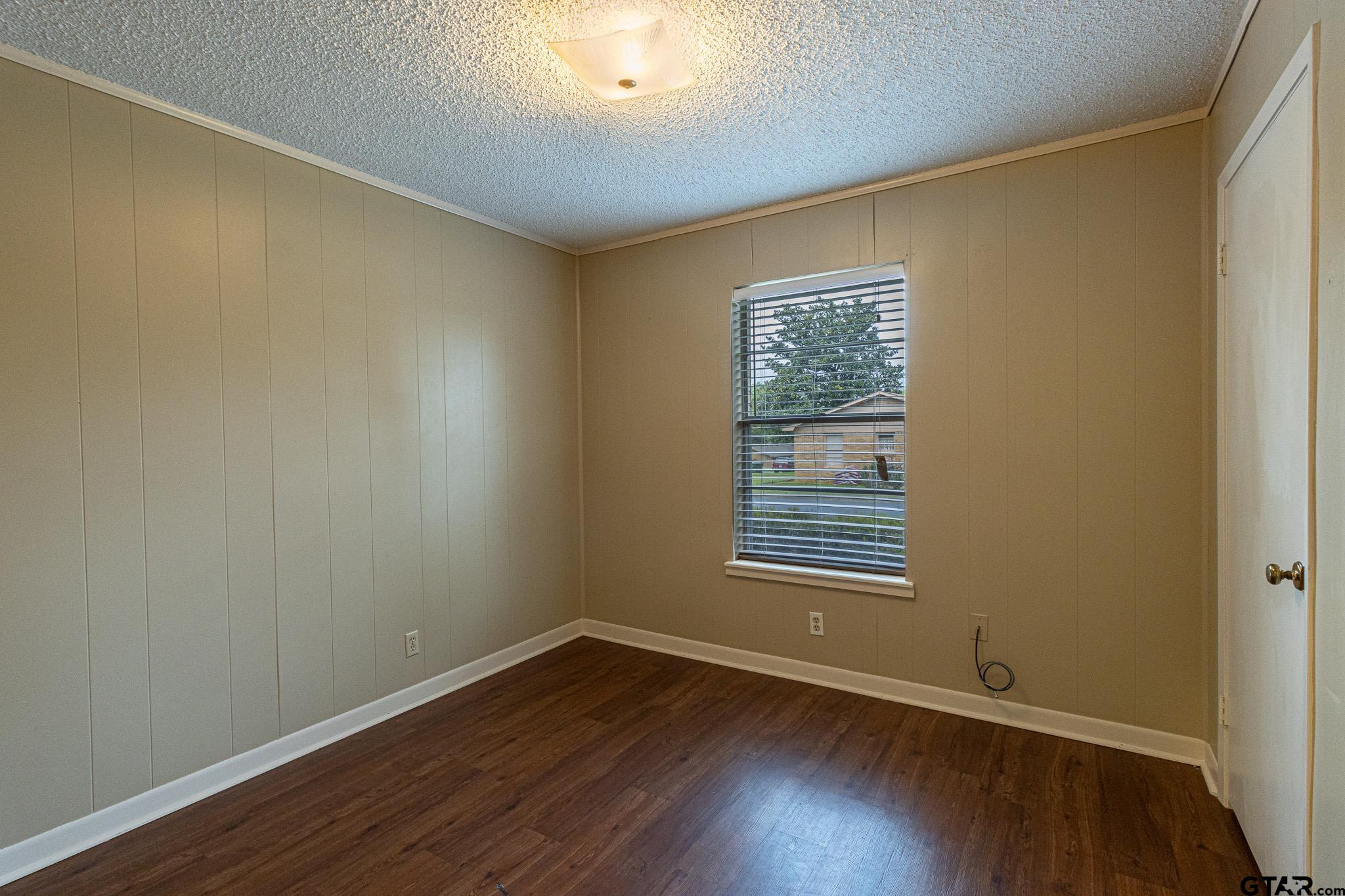 1202 Ridgeview Drive Tyler, TX 75701 - Photo 18 of 20 a view of an empty room with wooden floor and a window