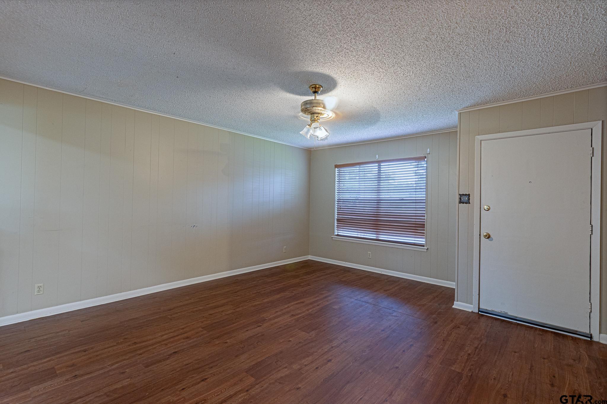 1202 Ridgeview Drive Tyler, TX 75701 - Photo 4 of 20 a view of an empty room with wooden floor and a window