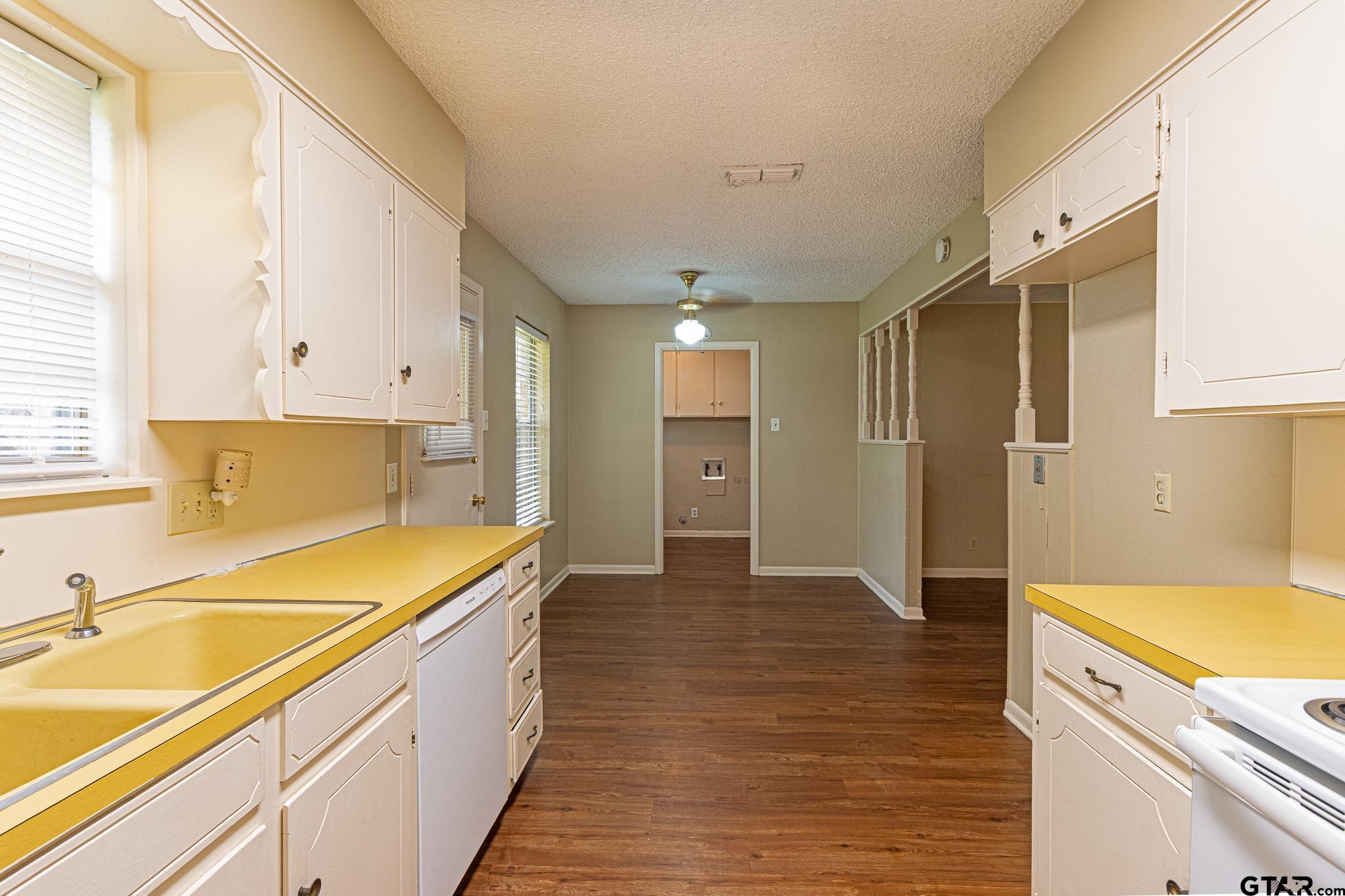 1202 Ridgeview Drive Tyler, TX 75701 - Photo 7 of 20 a view of a kitchen with a sink and dishwasher with wooden floor