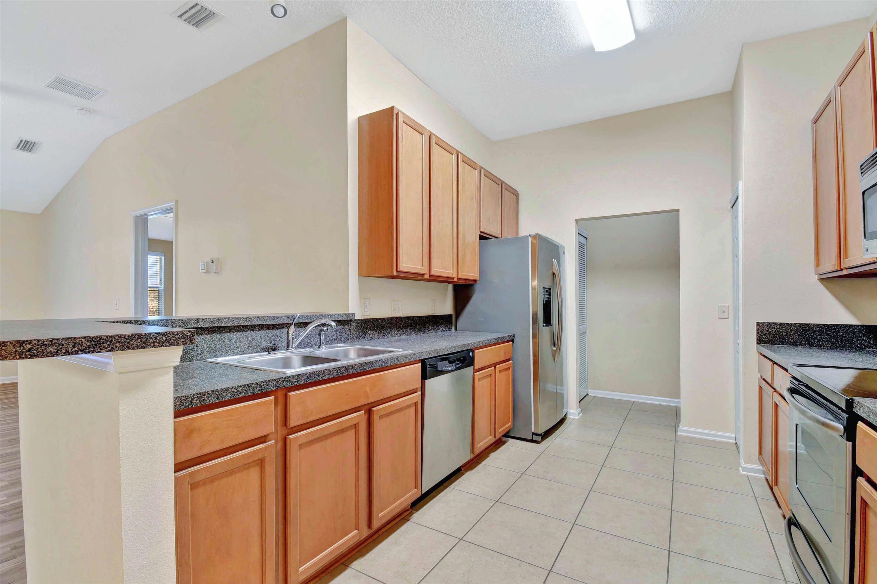 617 Golden Lake Loop St. Augustine, FL 32084 - Photo 7 of 25 a kitchen with stainless steel appliances granite countertop a sink and a refrigerator