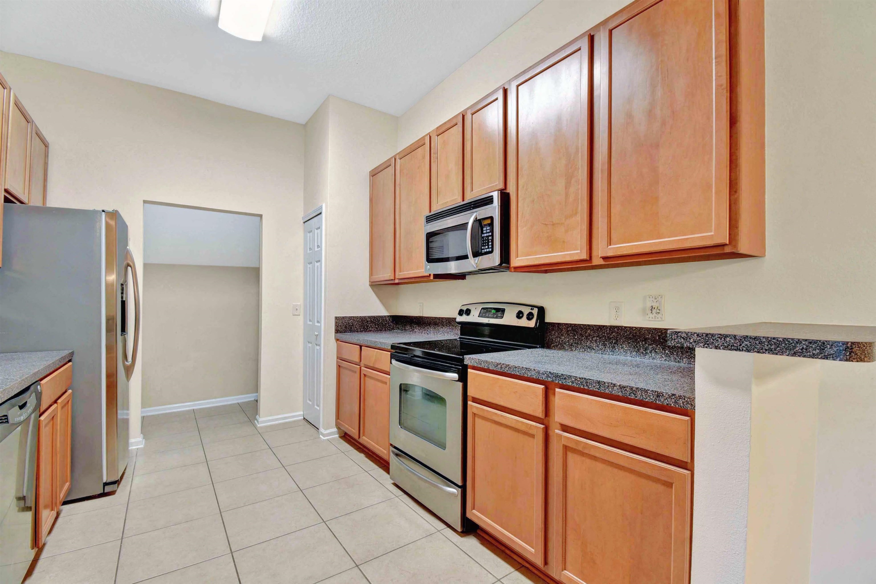 617 Golden Lake Loop St. Augustine, FL 32084 - Photo 8 of 25 a kitchen with stainless steel appliances granite countertop a refrigerator a stove a sink and dishwasher