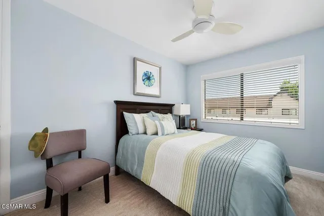 a bedroom with a bed window and a flat screen tv