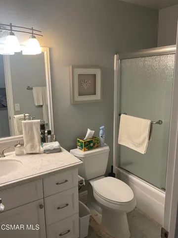 a bathroom with a sink mirror vanity and toilet