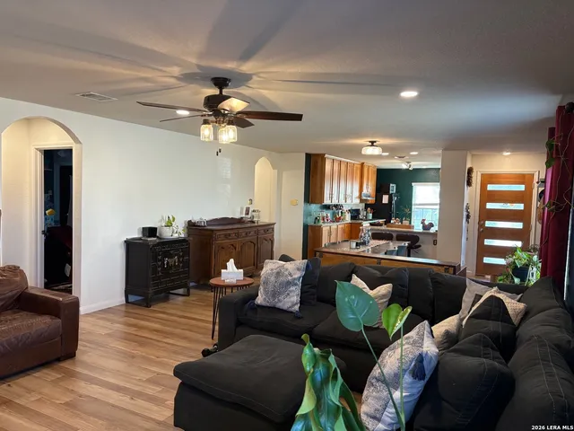 a living room with furniture kitchen view and a chandelier