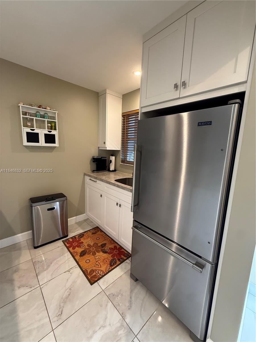 a kitchen with stainless steel appliances a refrigerator sink and cabinets