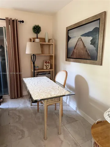 a room with table chairs and a refrigerator