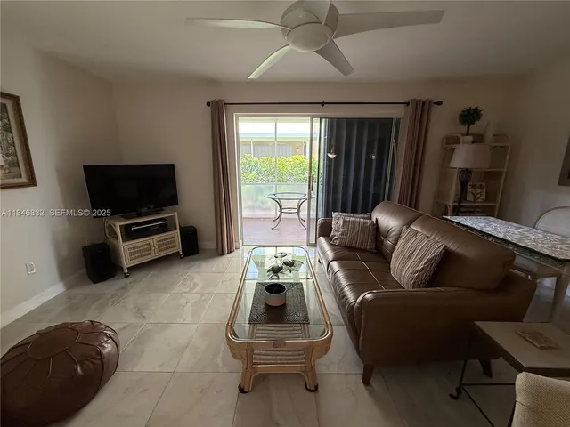 a living room with furniture a flat screen tv and a large window