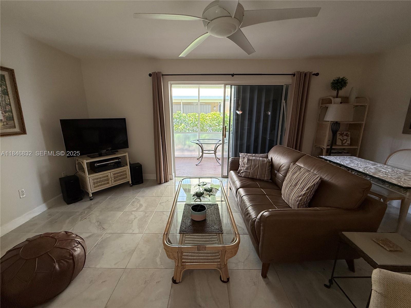 417 Waterside Drive Hypoluxo, FL 33462 - Photo 13 of 52 a living room with furniture a flat screen tv and a large window