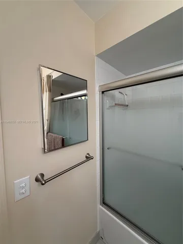 a bathroom with a glass shower door