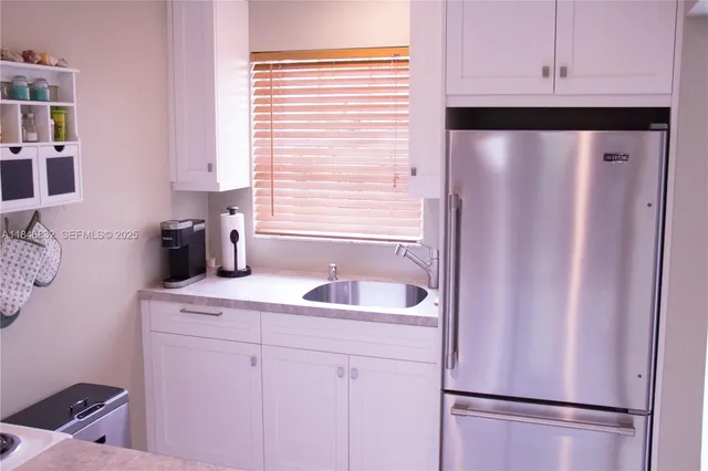 a kitchen with a refrigerator and a sink
