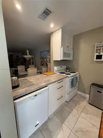 a kitchen with granite countertop a sink a stove and cabinets