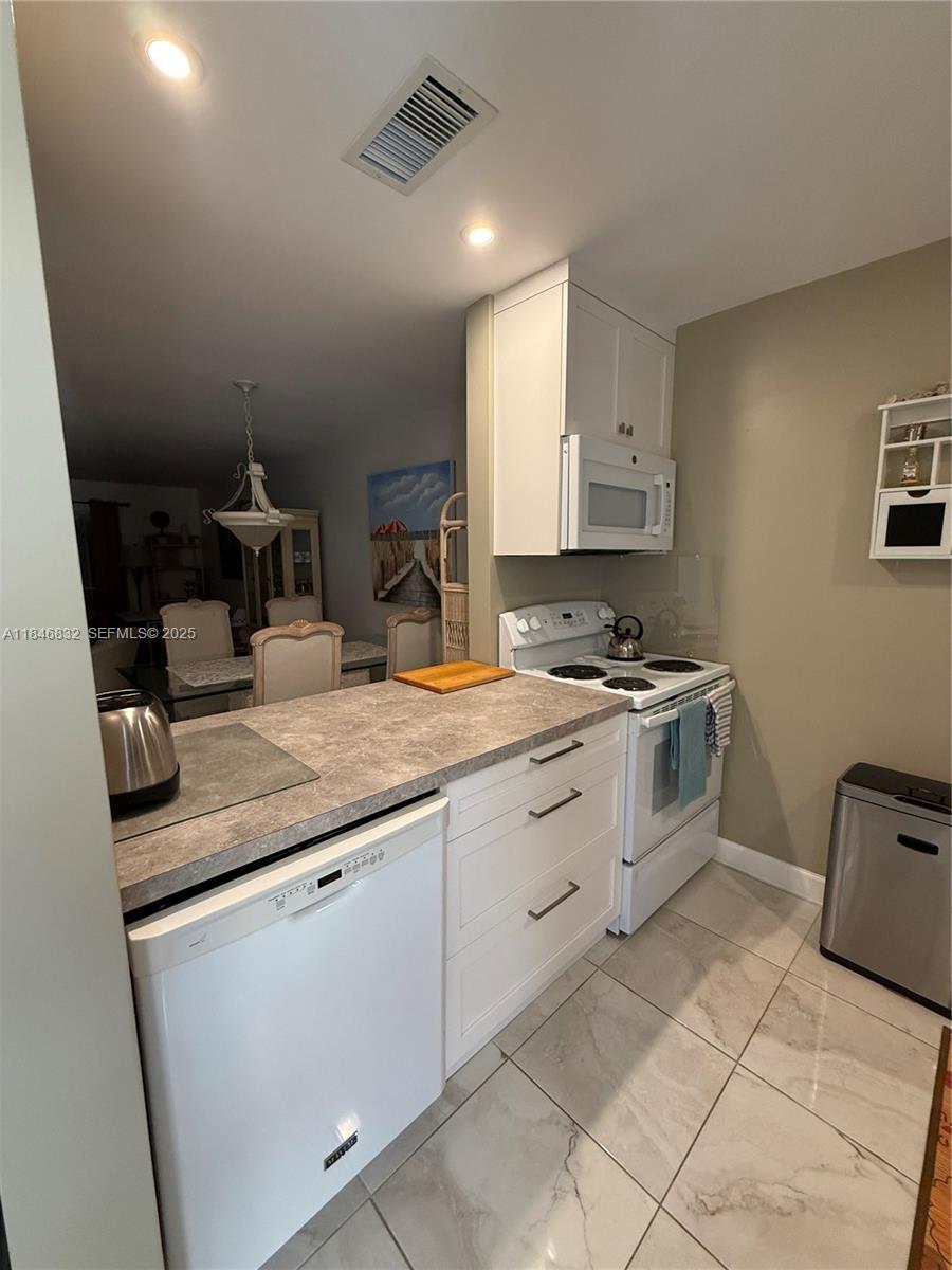 417 Waterside Drive Hypoluxo, FL 33462 - Photo 7 of 52 a kitchen with granite countertop a sink a stove and cabinets