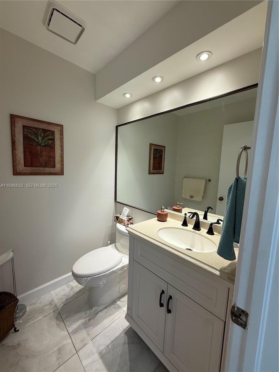 417 Waterside Drive Hypoluxo, FL 33462 - Photo 8 of 52 a bathroom with a toilet sink and mirror