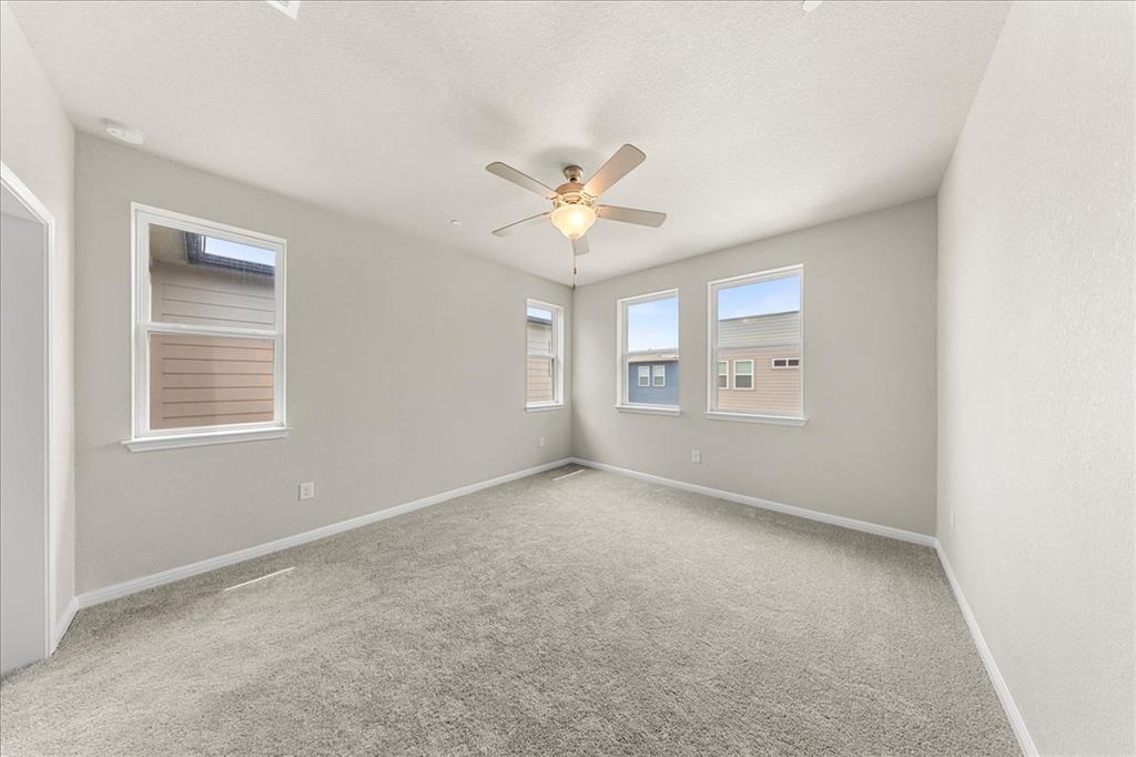 9015 Cattle Baron Path, Unit 1502 Austin, TX 78747 - Photo 10 of 31 Spare room featuring a ceiling fan, light carpet, and a textured ceiling