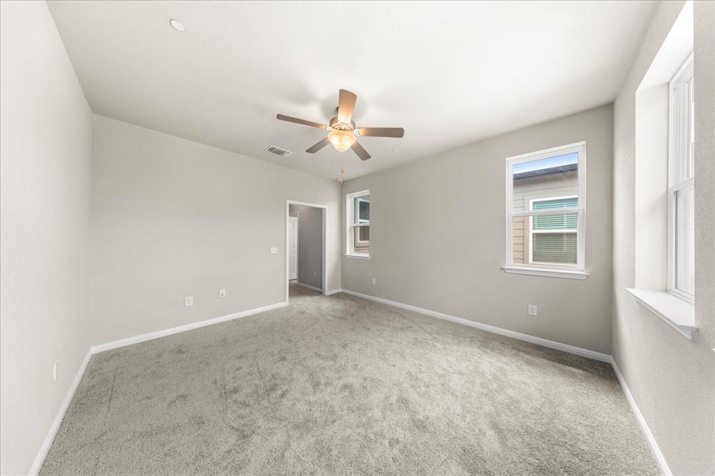 9015 Cattle Baron Path, Unit 1502 Austin, TX 78747 - Photo 11 of 31 Carpeted empty room with baseboards and a ceiling fan