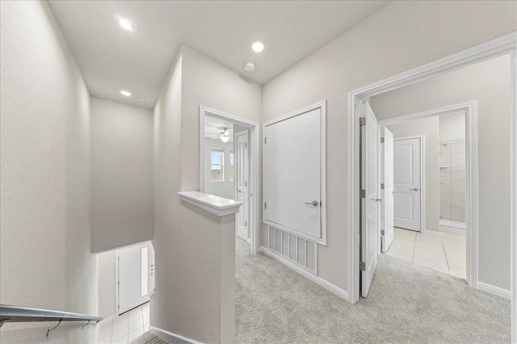 9015 Cattle Baron Path, Unit 1502 Austin, TX 78747 - Photo 24 of 31 Corridor featuring light colored carpet and baseboards