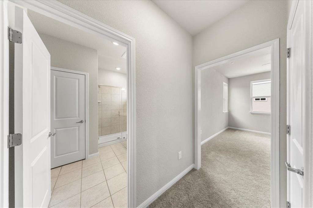 9015 Cattle Baron Path, Unit 1502 Austin, TX 78747 - Photo 28 of 31 Corridor featuring light tile patterned floors and light carpet