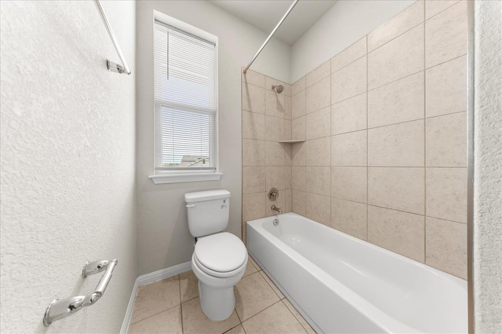 9015 Cattle Baron Path, Unit 1502 Austin, TX 78747 - Photo 28 of 32 Full bathroom with shower / tub combination, light tile patterned floors, and a textured wall