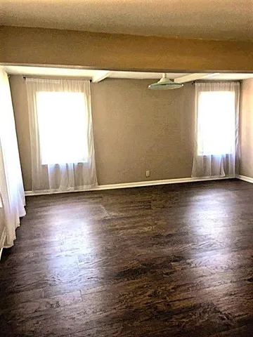 a view of a room with wooden floor and a window