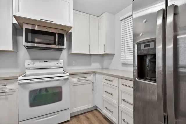 a kitchen with cabinets stainless steel appliances and a sink