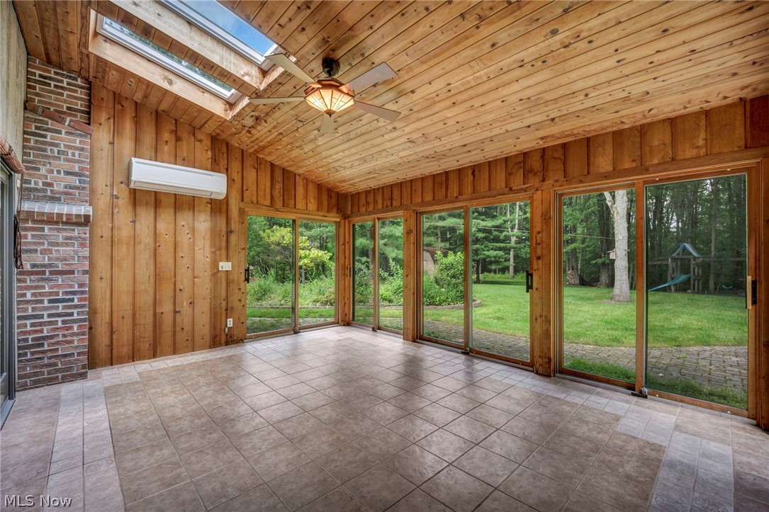 6845 Liberty Road Solon, OH 44139 - Photo 17 of 47 Sunroom featuring a wood-panel ceiling with skylights, ceiling fan, and tile flooring